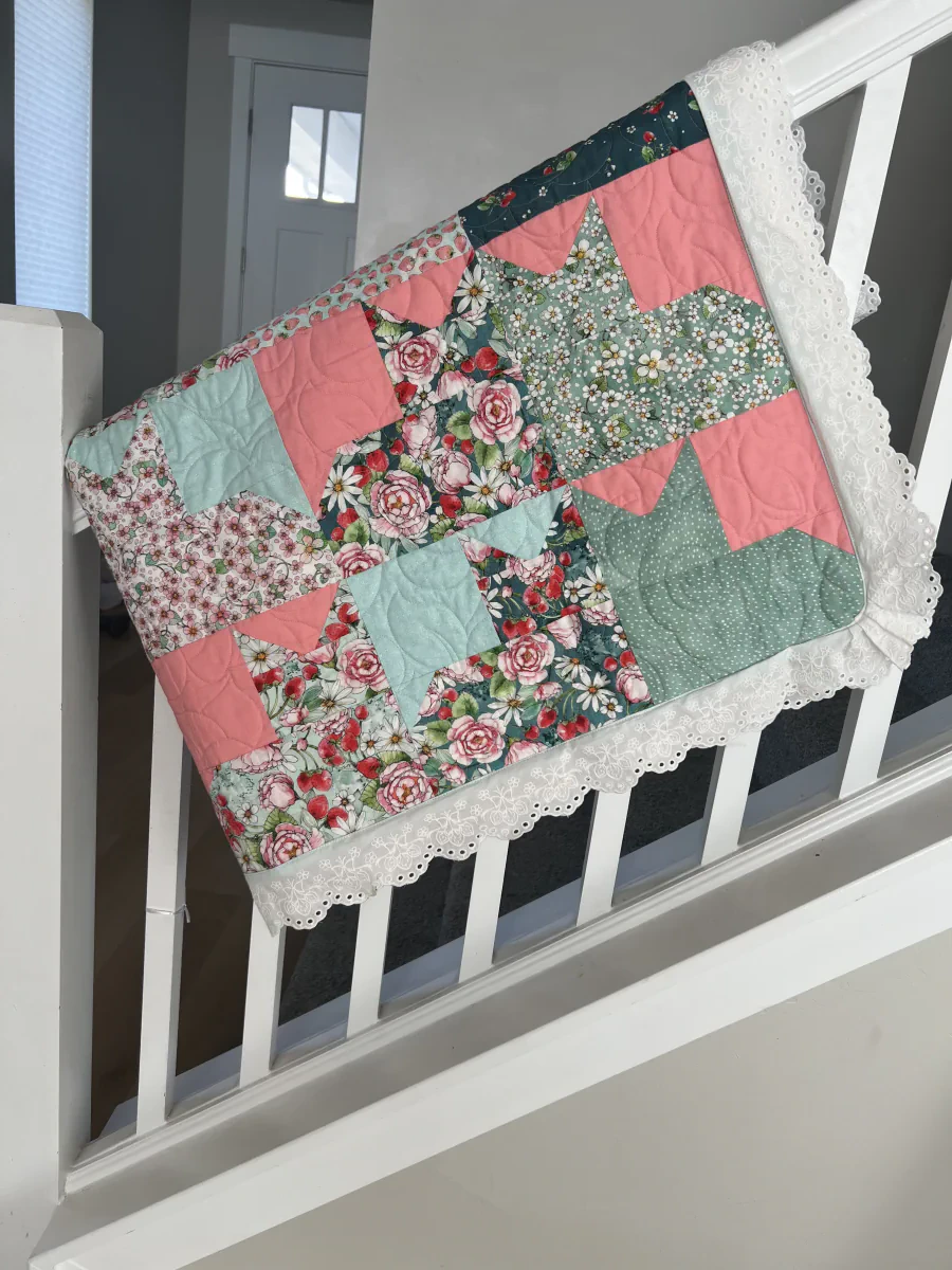 Patchwork quilt with white embroidered eyelet lace edging